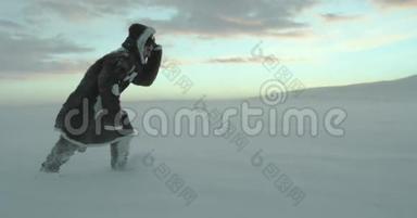 一位年轻疲惫的游客在暴风雪中沿着冬天的田野离开。 红色史诗电影摄影机4k。 亚马尔2016。 高清高清